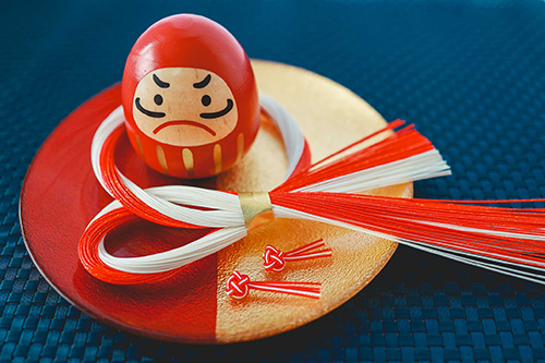 無料でおしゃれな年賀状デザイン：赤と金の和食器に乗ったお正月飾りとダルマ｜がりどろ年賀状2026