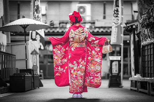 無料でおしゃれな年賀状デザイン：白黒の街並みに映える赤い着物を着た女の子｜がりどろ年賀状2026